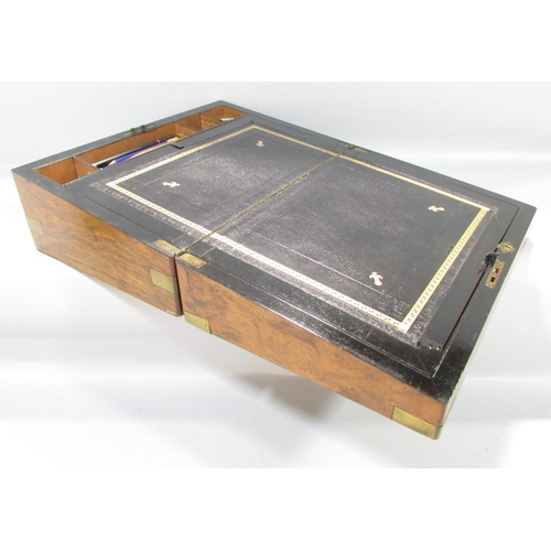 569 - A Georgian walnut writing slope with a black leather lined interior.