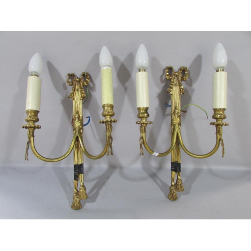 604 - A pair of Regency style gilt swag and bow wall lights, a gold contemporary wall light with overlappi... 