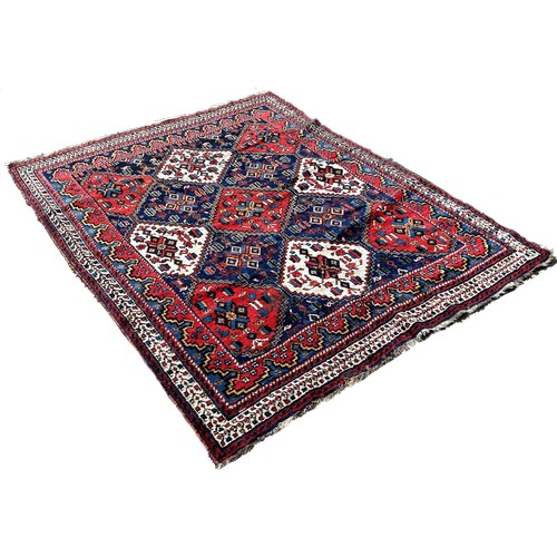 1772 - An Afghan rug, with red white and blue alternating diamond medallions 195cm x 150cm approximately