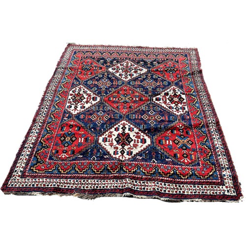 1772 - An Afghan rug, with red white and blue alternating diamond medallions 195cm x 150cm approximately