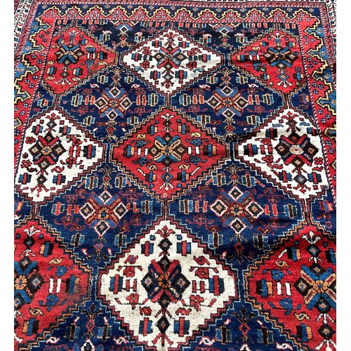 1772 - An Afghan rug, with red white and blue alternating diamond medallions 195cm x 150cm approximately