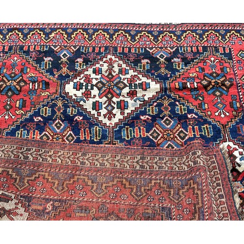 1772 - An Afghan rug, with red white and blue alternating diamond medallions 195cm x 150cm approximately