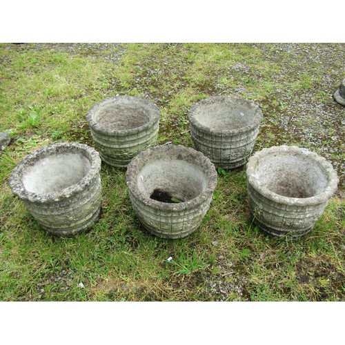 1067 - A set of five matching circular cast composition stone barrel shaped planters, with repeating flower... 