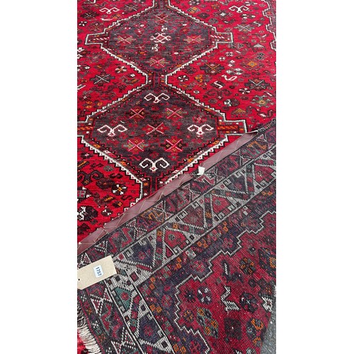 1757 - A Persian carpet with three interlocking medallions on a predominantly red ground, 240cm x 170cm app... 