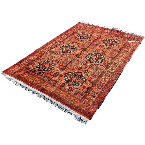 1760 - A Persian style carpet with alternating guls on a faded red ground, 199cm x 144cm.