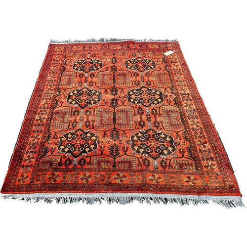 1760 - A Persian style carpet with alternating guls on a faded red ground, 199cm x 144cm.