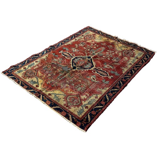 1764 - An antique Heriz rug with a radiating central medallion on a pink ground  and a trailing floral bord... 