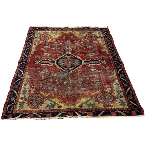 1764 - An antique Heriz rug with a radiating central medallion on a pink ground  and a trailing floral bord... 