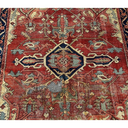 1764 - An antique Heriz rug with a radiating central medallion on a pink ground  and a trailing floral bord... 