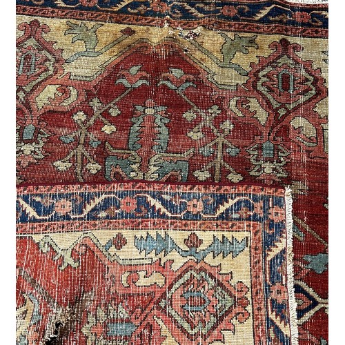 1764 - An antique Heriz rug with a radiating central medallion on a pink ground  and a trailing floral bord... 