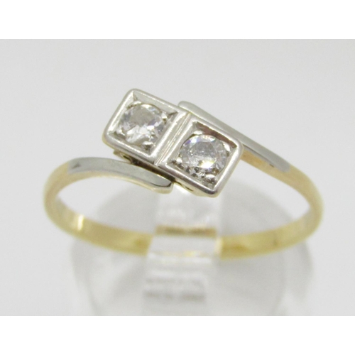 390 - Two stone diamond crossover ring in yellow metal with white metal setting, each stone 0.10ct approx,... 