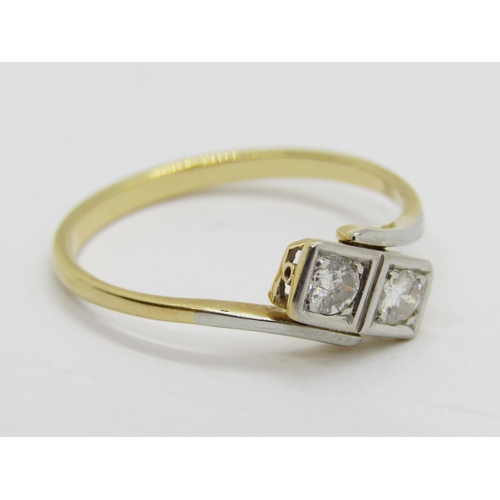 390 - Two stone diamond crossover ring in yellow metal with white metal setting, each stone 0.10ct approx,... 