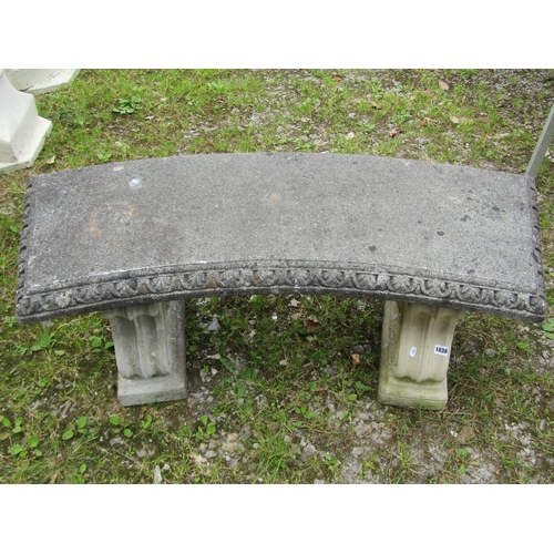 1038 - A weathered cast composition stone three sectional garden bench with curved slab seat raised on scro... 