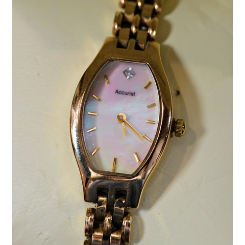 472 - Accurist: A lady's 9ct yellow gold cased wristwatch, with polished shell dial, on 9ct yellow gold st... 