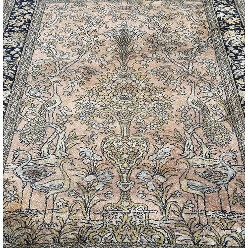 1796 - A Persian style carpet with exotic bird amongst flowers on a faded pink ground, 220cm 170cm approxim... 