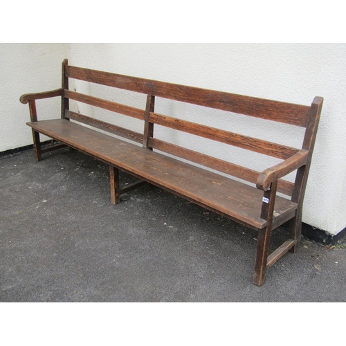 1671 - A long vintage stained pine chapel bench with triple railed back, open scrolled arms, tapered plank ... 