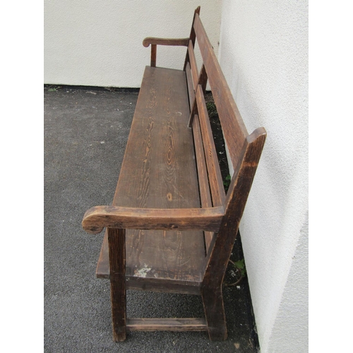 1671 - A long vintage stained pine chapel bench with triple railed back, open scrolled arms, tapered plank ... 