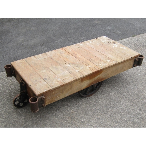 1675 - A vintage four-wheeled platform trolley, with hardwood boarded bed and cast iron fittings, (likely e... 