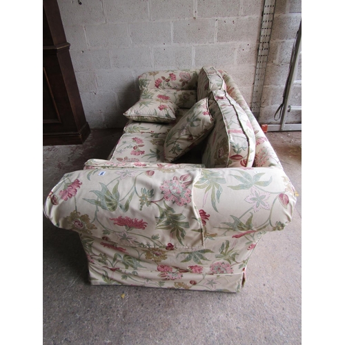 1695 - A traditional sofa with rolled arms, cream floral upholstery and loose seat and back cushions, appro... 