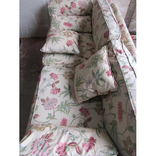 1695 - A traditional sofa with rolled arms, cream floral upholstery and loose seat and back cushions, appro... 