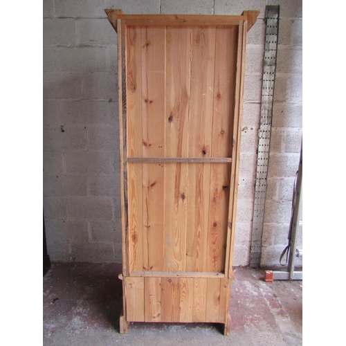 1698 - A reclaimed pine wardrobe enclosed by a three quarter length twin moulded panelled door over a long ... 