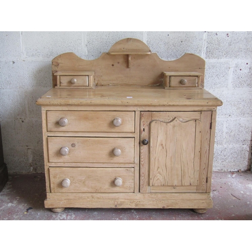 1700 - A small Victorian stripped pine dresser partially enclosed by a fielded panelled door and 3 long dra... 