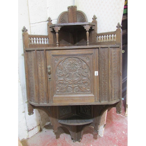 1704 - A late Victorian arts and crafts oak hanging corner cupboard, with well detailed and carved floral a... 