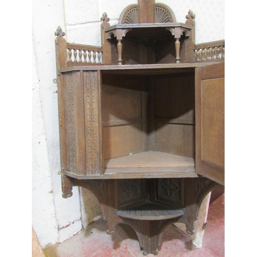 1704 - A late Victorian arts and crafts oak hanging corner cupboard, with well detailed and carved floral a... 