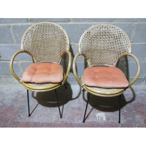 1713 - A pair of vintage cane chairs with lattice backs and circular seats raised on steel supports