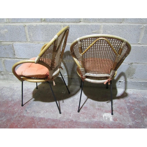 1713 - A pair of vintage cane chairs with lattice backs and circular seats raised on steel supports