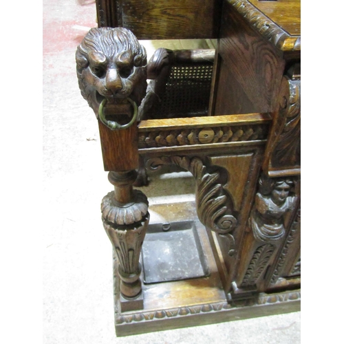 1721 - A large Victorian Gothic oak hall stand, with profusely carved detail, the raised back incorporating... 