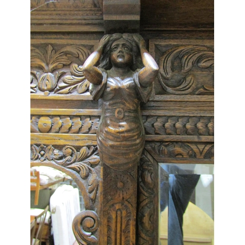 1721 - A large Victorian Gothic oak hall stand, with profusely carved detail, the raised back incorporating... 