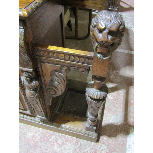 1721 - A large Victorian Gothic oak hall stand, with profusely carved detail, the raised back incorporating... 