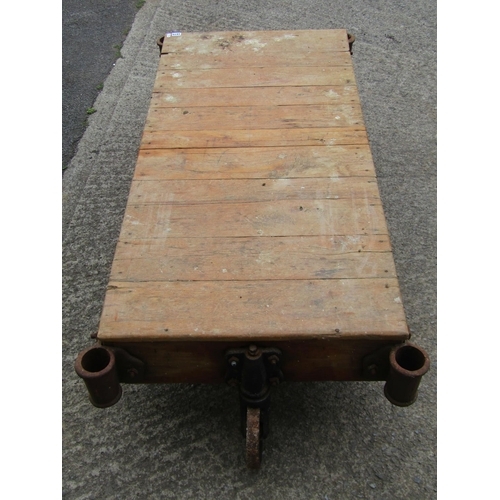 1675 - A vintage four-wheeled platform trolley, with hardwood boarded bed and cast iron fittings, (likely e... 