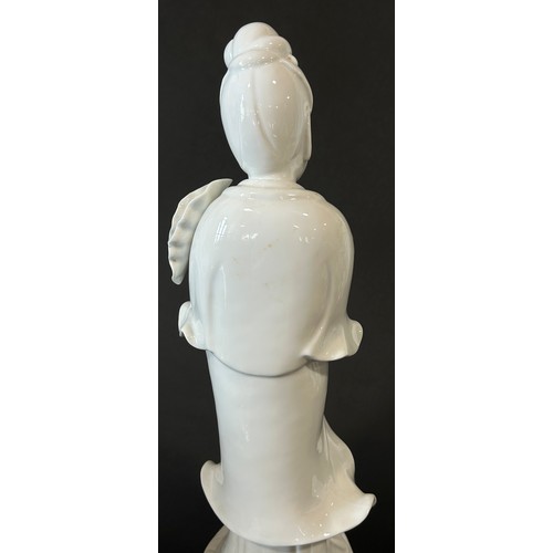 39 - A large Chinese blanc de chine figure of Guaynin, presented standing upon a Lotus pad, clutching Lot... 