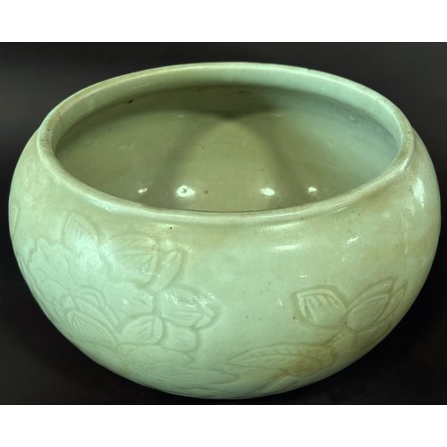 42 - A Chinese celadon glazed moulded porcelain alms bowl of open bulbous form, decorated with incised fl... 