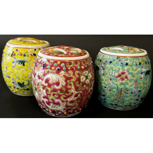 48 - A trio of Chinese export porcelain lidded jars of cylindrical form in shades of yellow, green and re... 