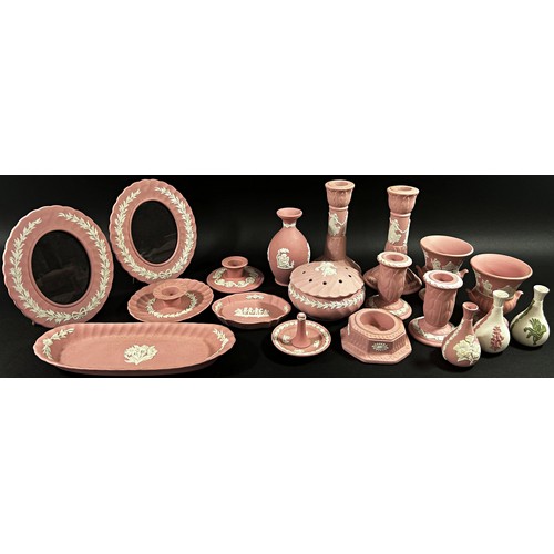 102 - A large Collection of pink ground Wedgwood jasperware to include candlesticks, posy vases, picture f... 