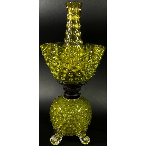 143 - A decorative Victorian yellow glass oil lamp with nobbled globular bowl raised on scrolled legs with... 