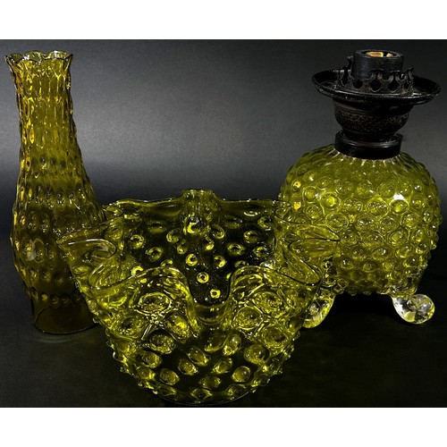 143 - A decorative Victorian yellow glass oil lamp with nobbled globular bowl raised on scrolled legs with... 