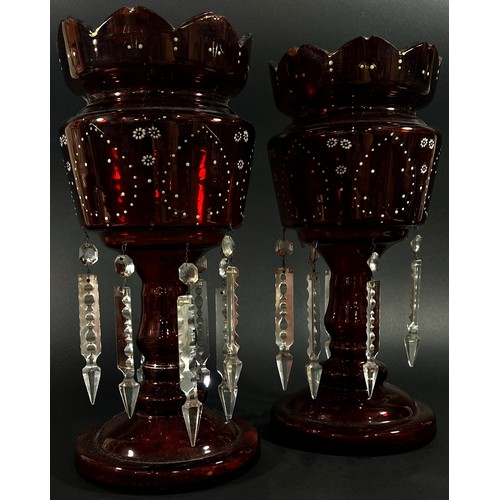 144 - A pair of Victorian red glass table lustres with enamelled detail and hanging clear cut prism drople... 