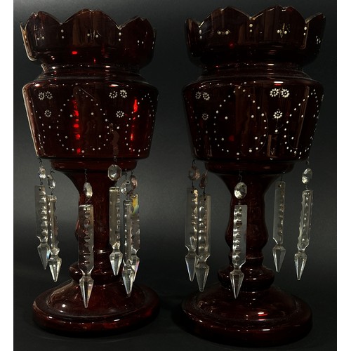 144 - A pair of Victorian red glass table lustres with enamelled detail and hanging clear cut prism drople... 