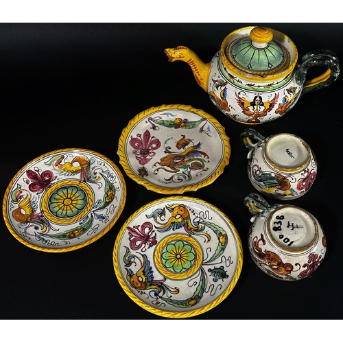 103 - A small group of continental faience glazed items to include teapot, jug, dishes, two tea cups, lidd... 