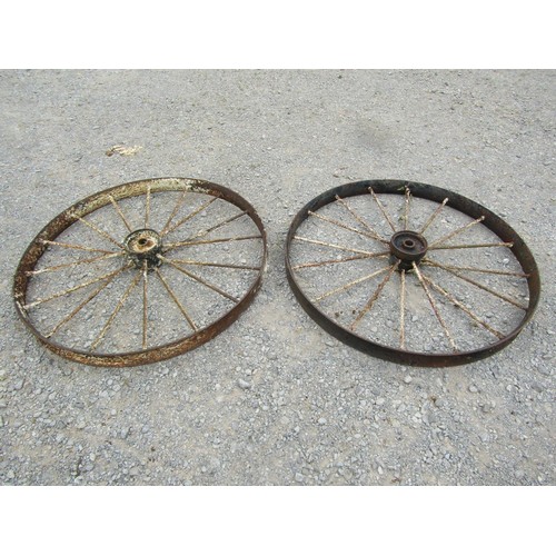 1164 - A pair of antique painted and weathered cast iron implement wheels 118 cm diameter