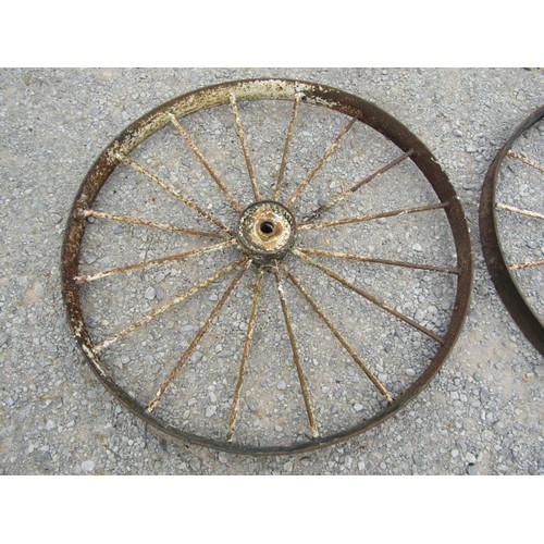 1164 - A pair of antique painted and weathered cast iron implement wheels 118 cm diameter