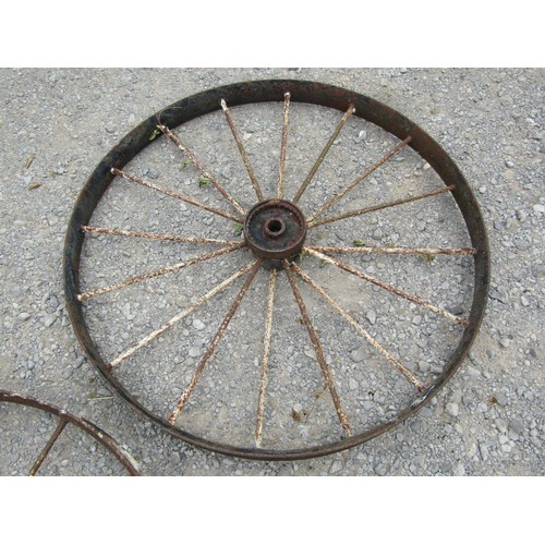 1164 - A pair of antique painted and weathered cast iron implement wheels 118 cm diameter