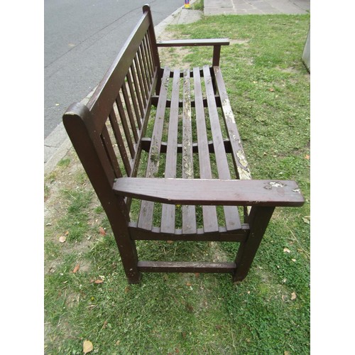 1182 - A vintage stained teak three seat garden bench with slatted seat and back, 159 cm long (af)