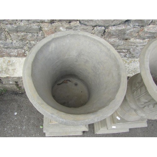 1189 - A pair of cast composition stone trumpet shaped garden urns with flared rims and leaf moulded detail... 