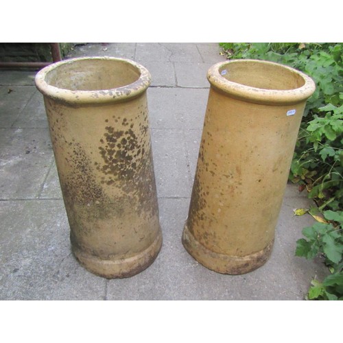 1190 - A pair of weathered buff coloured cylindrical chimney pots, 60 cm high