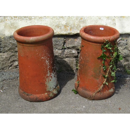 1191 - A pair of weathered terracotta chimney pots of squat cylindrical form with moulded rims, 46 cm high